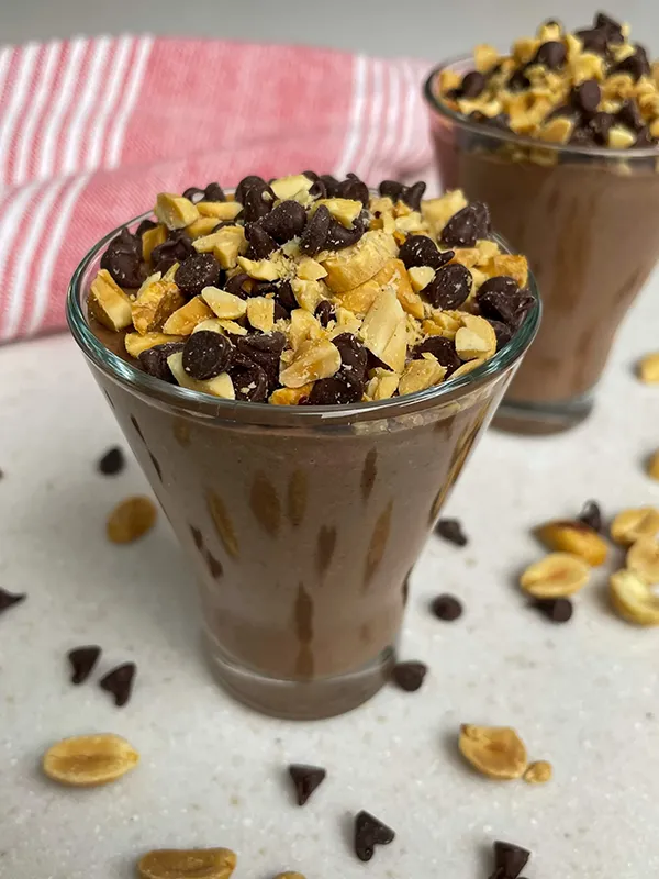 in two small glasses chocolate chia puddings with pistachio